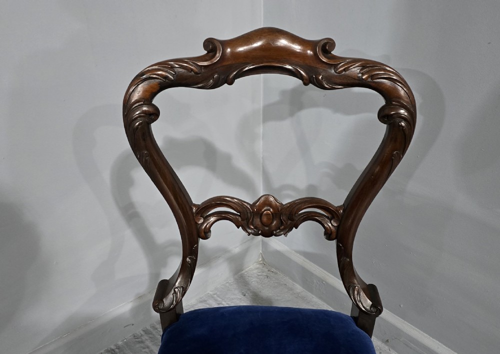A Victorian rosewood side chair featuring an openwork balloon back, blue velvet upholstered seat, and cabriole legs. View VI