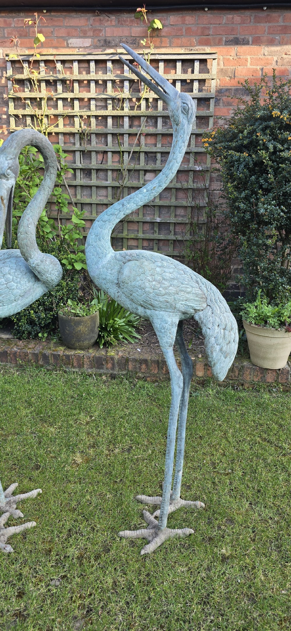 A pair of large cast metal crane statues featuring a weathered verdigris green finish and detailed feather texturing. View II