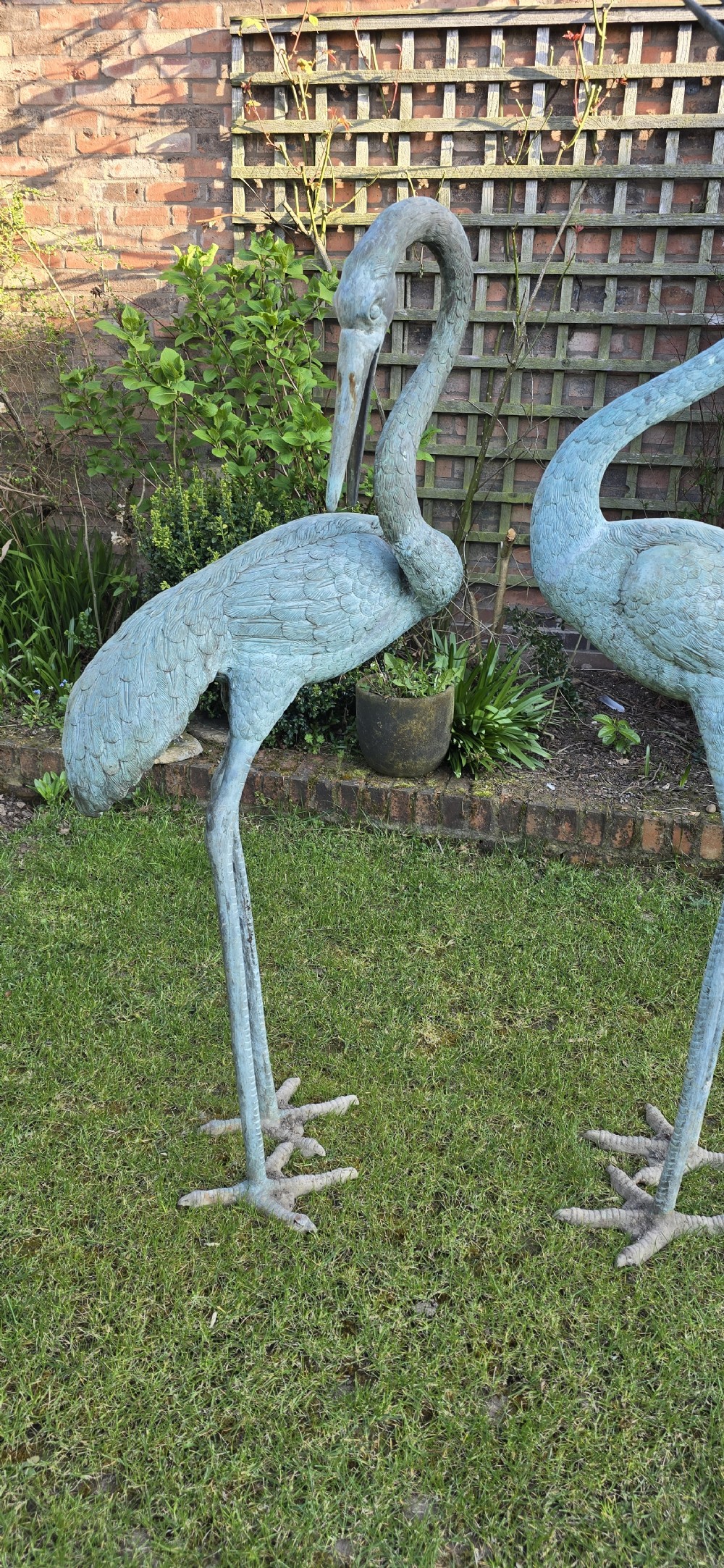 A pair of large cast metal crane statues featuring a weathered verdigris green finish and detailed feather texturing. View III