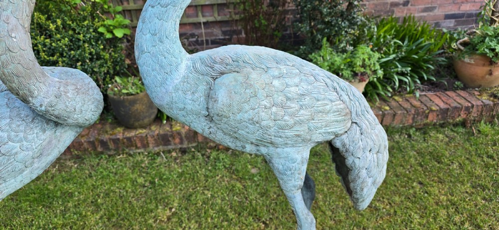 A pair of large cast metal crane statues featuring a weathered verdigris green finish and detailed feather texturing. View VII