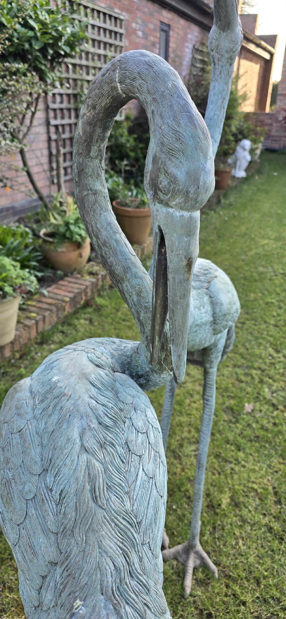 A pair of large cast metal crane statues featuring a weathered verdigris green finish and detailed feather texturing. View XIV