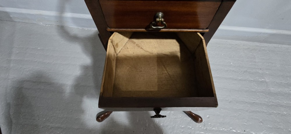 An eighteenth-century Georgian mahogany wig stand featuring a circular top ring, curved upright supports, a central triangular drawer section, and a tripod base with pad feet. View VI