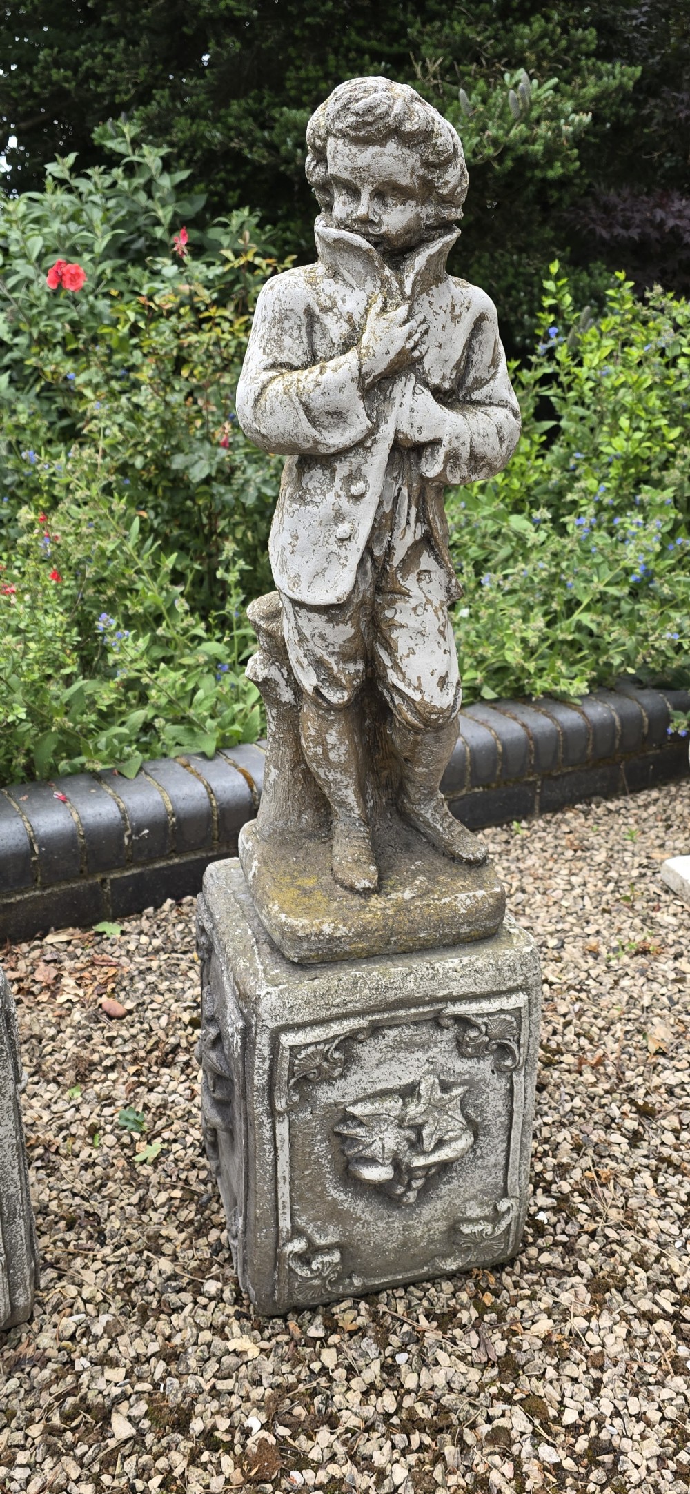 A set of four weathered grey cast stone statues representing the Four Seasons standing on matching square relief-decorated pedestals. View VI