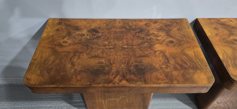 A pair of Art Deco console tables crafted from figured burr walnut, featuring overhanging rectangular tops with rounded edges set on thick rectangular pedestal bases. View III