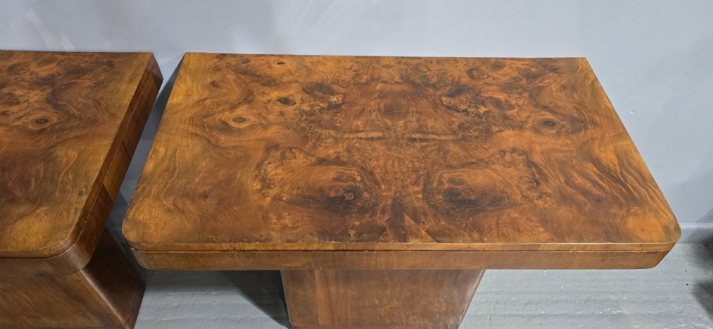 A pair of Art Deco console tables crafted from figured burr walnut, featuring overhanging rectangular tops with rounded edges set on thick rectangular pedestal bases. View V