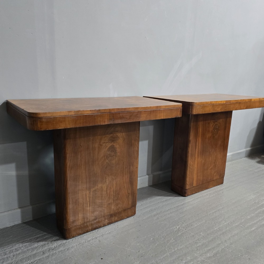 A pair of Art Deco console tables crafted from figured burr walnut, featuring overhanging rectangular tops with rounded edges set on thick rectangular pedestal bases. View VIII