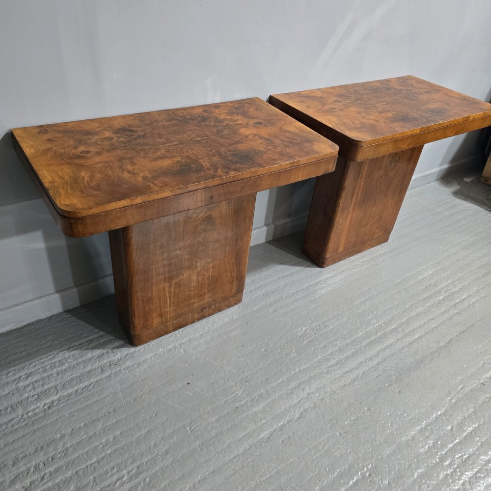 A pair of Art Deco console tables crafted from figured burr walnut, featuring overhanging rectangular tops with rounded edges set on thick rectangular pedestal bases. View IX