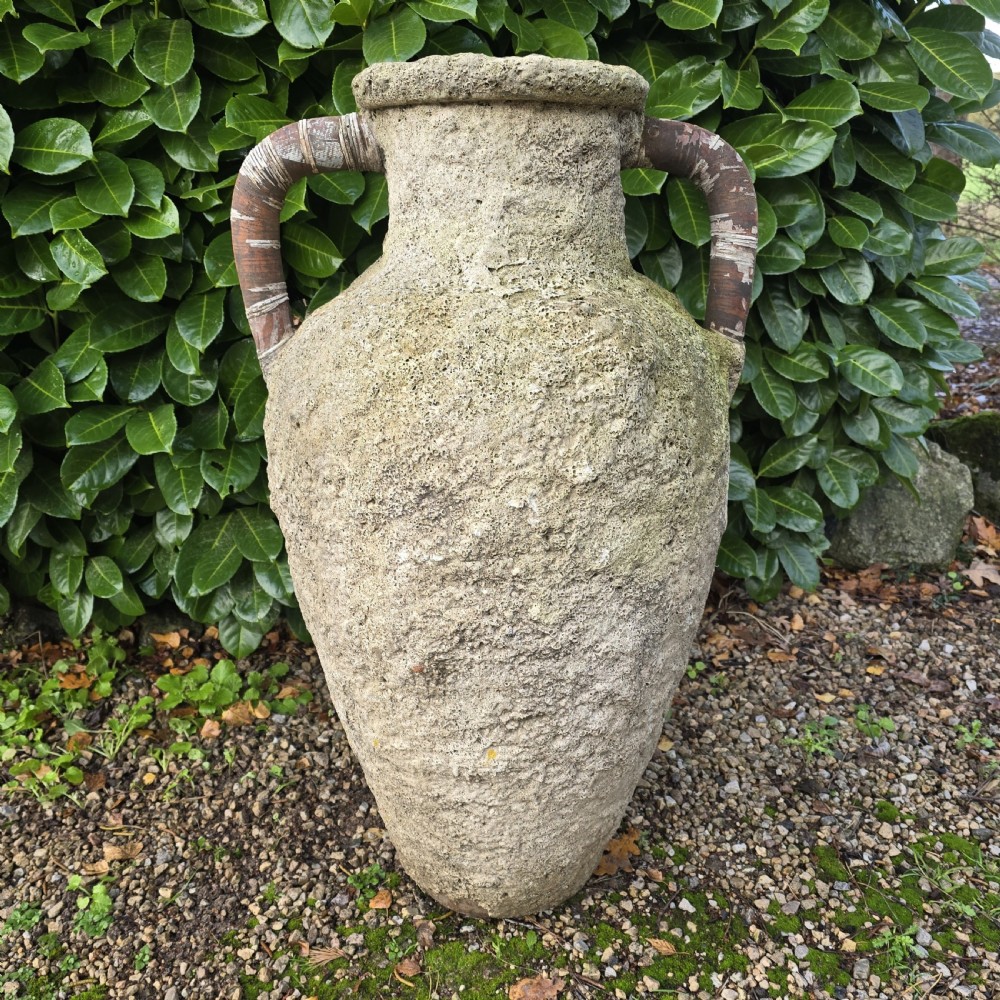 A large, heavily textured terracotta oil jar with a rounded body, narrow base, rolled rim, and twin loop handles.