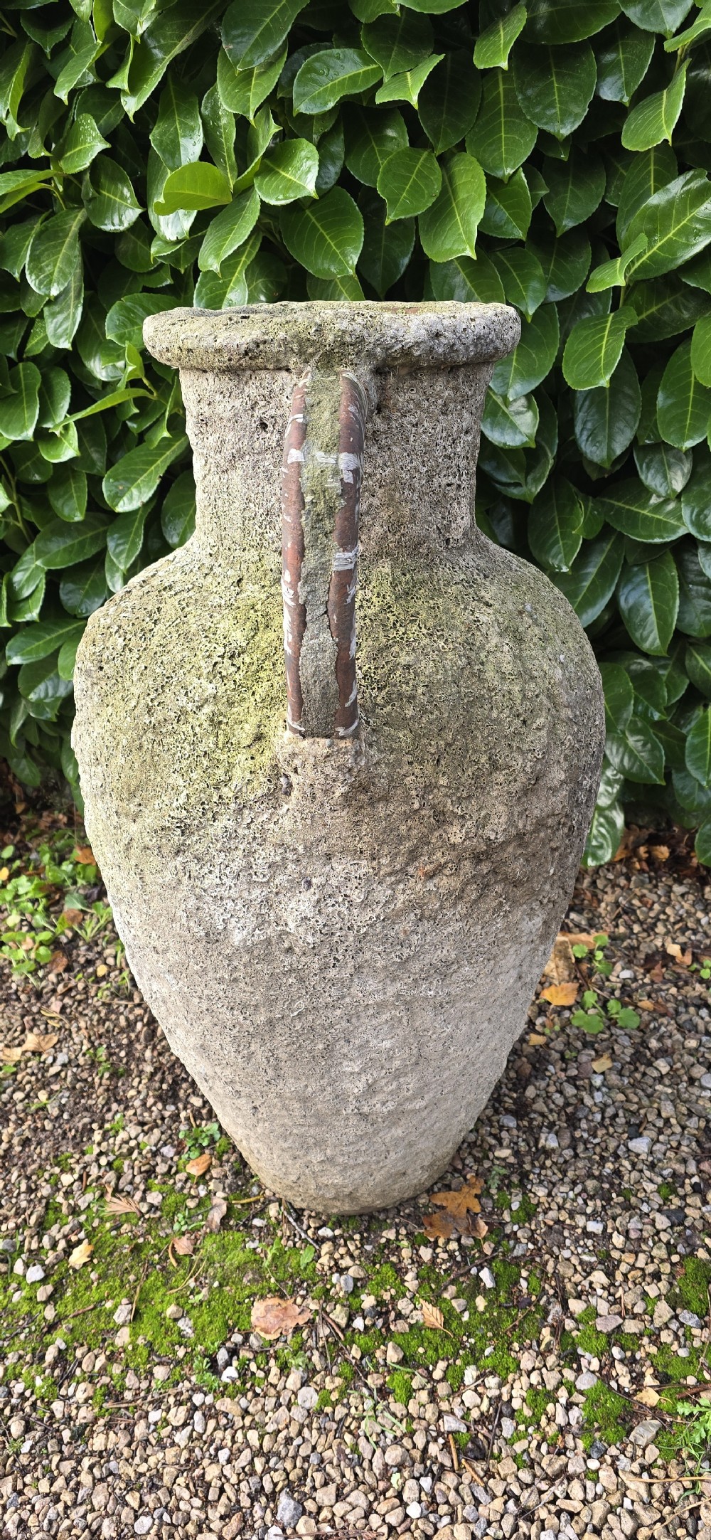 A large, heavily textured terracotta oil jar with a rounded body, narrow base, rolled rim, and twin loop handles. View III