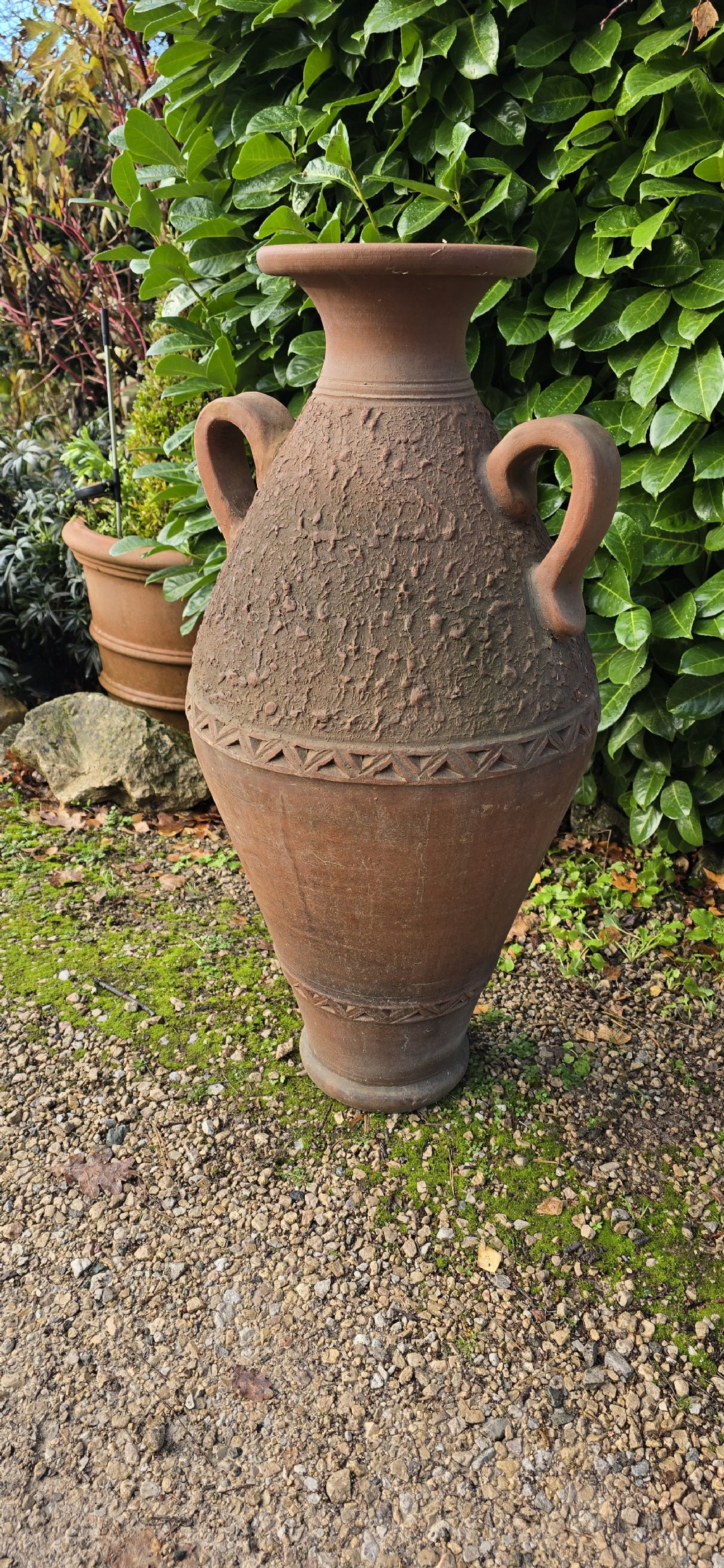 A large terracotta oil jar with two side handles, a textured upper body, and incised geometric patterning. View IV