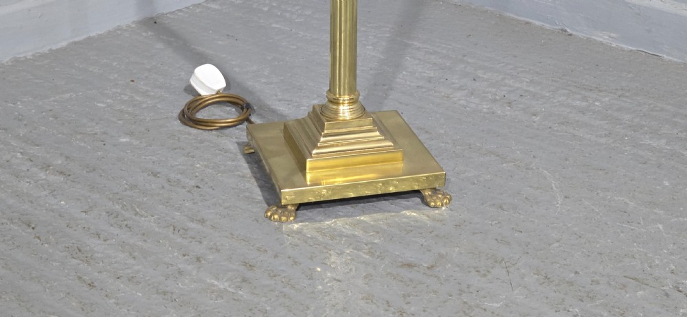 A solid brass standard lamp featuring a fluted Corinthian column stem, stepped square base on paw feet, and a pleated pink fabric shade with tassel fringe. View III