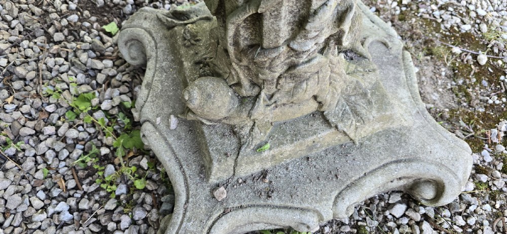 A weathered cast stone pedestal bird bath featuring relief carvings of foliage, birds, and a mouse around the column, resting on a scroll-cornered base. View VIII