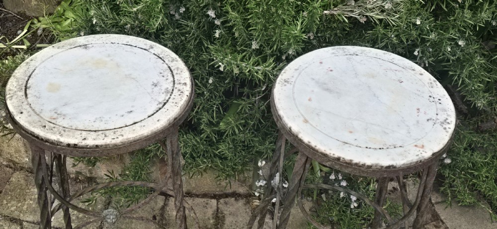 A pair of tall wrought iron plant stands with circular stone tops, twisted legs, and central lion mask medallion details. View IV