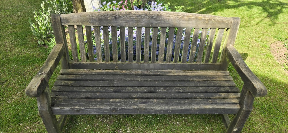 A weathered silver-grey teak garden bench featuring a slatted backrest, slatted seat, wide armrests, and straight post legs. View III