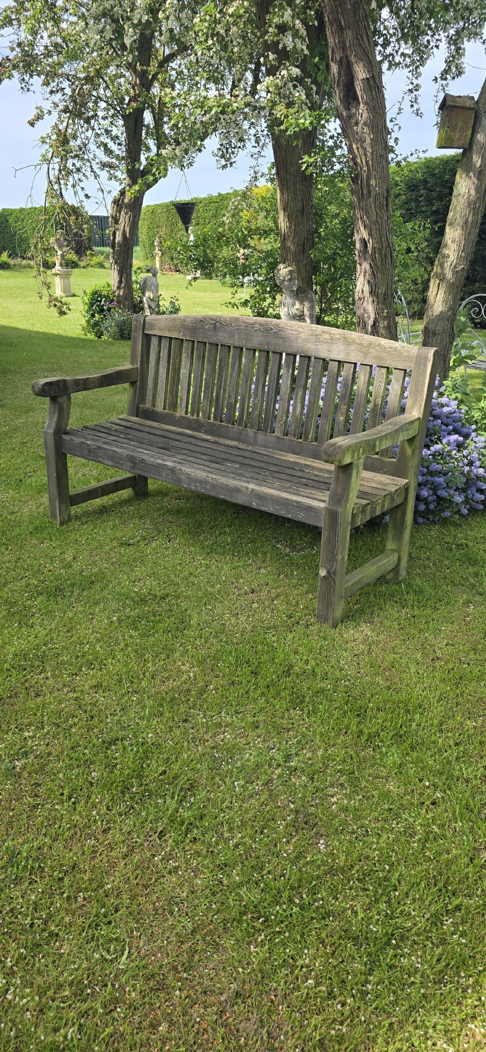 A weathered silver-grey teak garden bench featuring a slatted backrest, slatted seat, wide armrests, and straight post legs. View IV