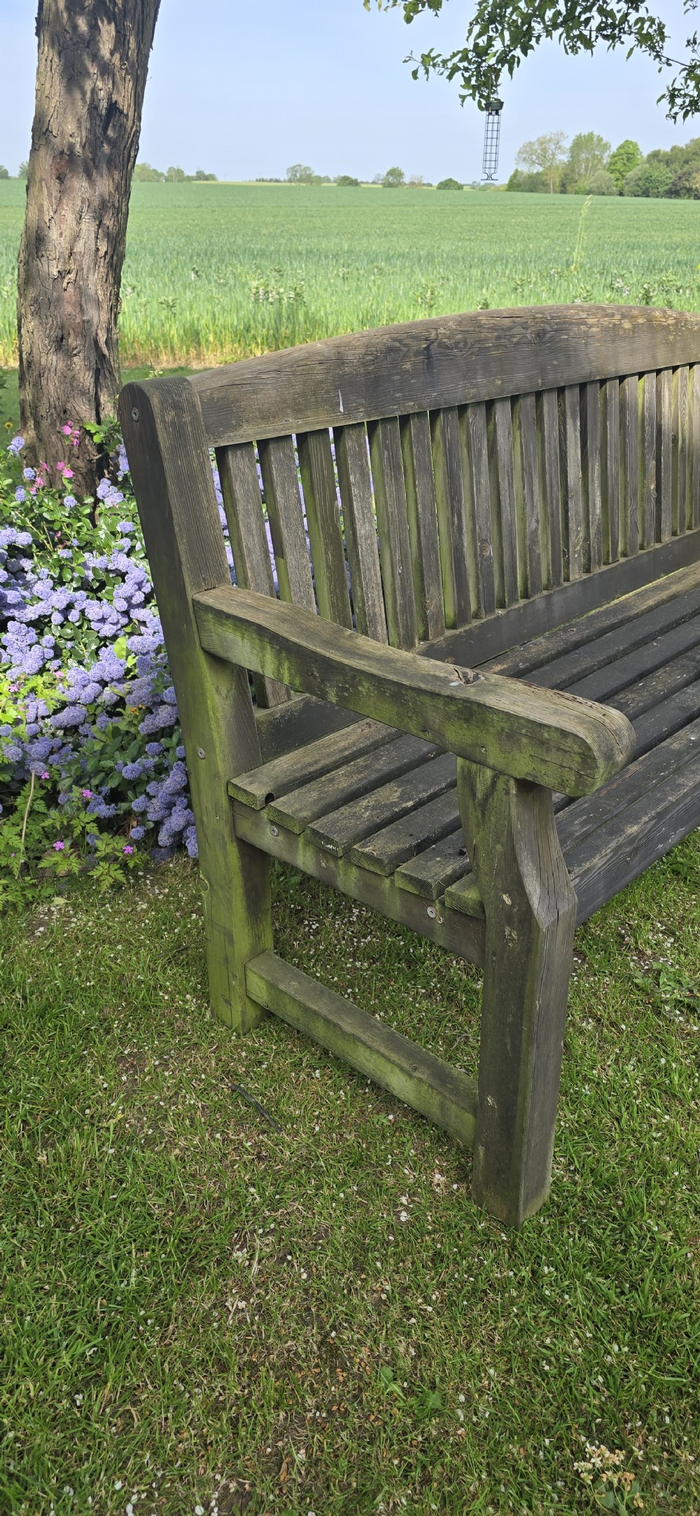 A weathered silver-grey teak garden bench featuring a slatted backrest, slatted seat, wide armrests, and straight post legs. View VII