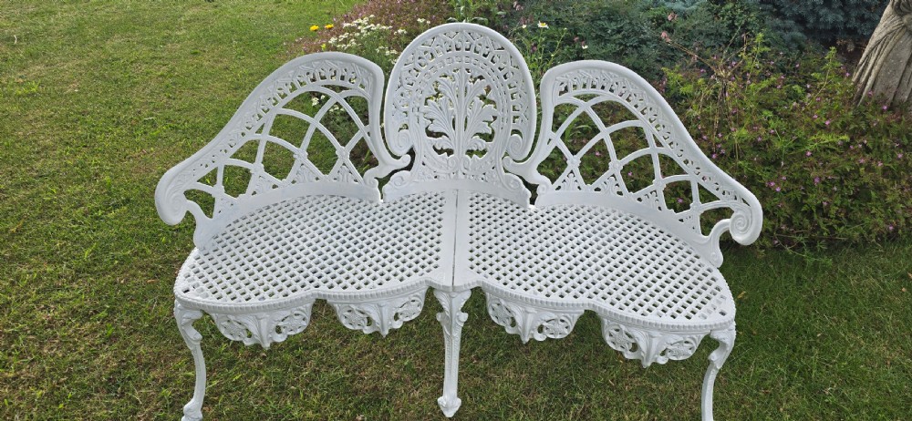 A refurbished white cast metal garden bench featuring an ornate lattice seat, three-part curved backrest with foliage motifs, and decorative legs. View IV