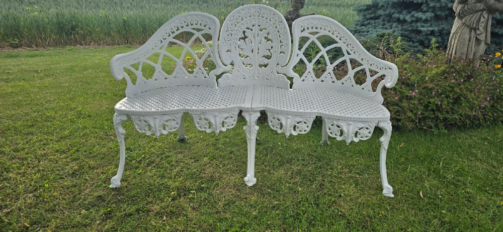 A refurbished white cast metal garden bench featuring an ornate lattice seat, three-part curved backrest with foliage motifs, and decorative legs. View V