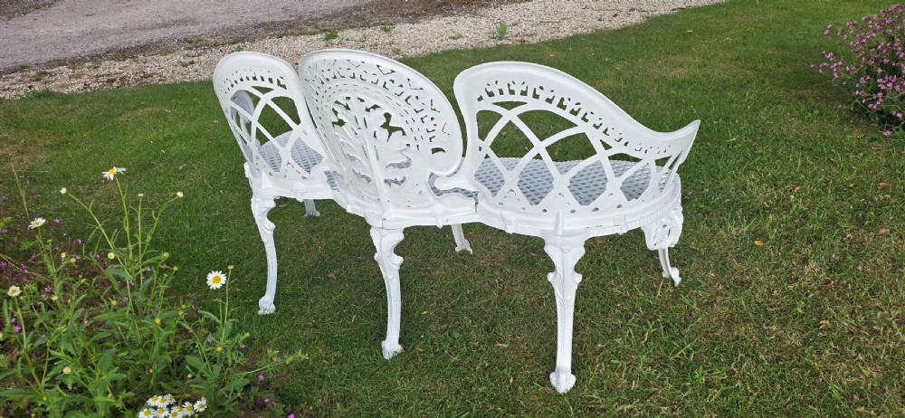 A refurbished white cast metal garden bench featuring an ornate lattice seat, three-part curved backrest with foliage motifs, and decorative legs. View VIII