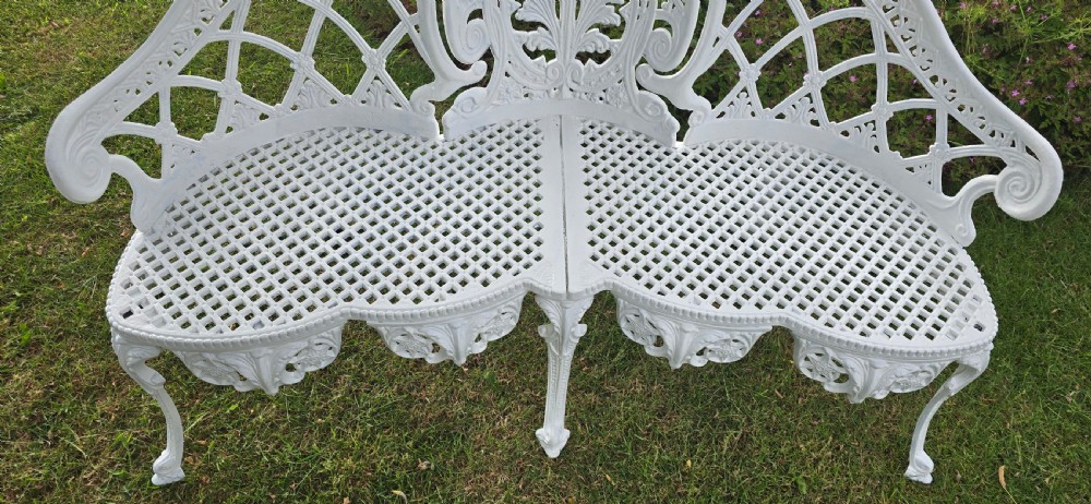 A refurbished white cast metal garden bench featuring an ornate lattice seat, three-part curved backrest with foliage motifs, and decorative legs. View IX