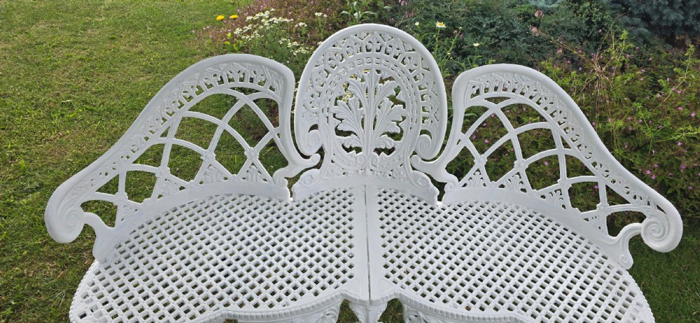 A refurbished white cast metal garden bench featuring an ornate lattice seat, three-part curved backrest with foliage motifs, and decorative legs. View X