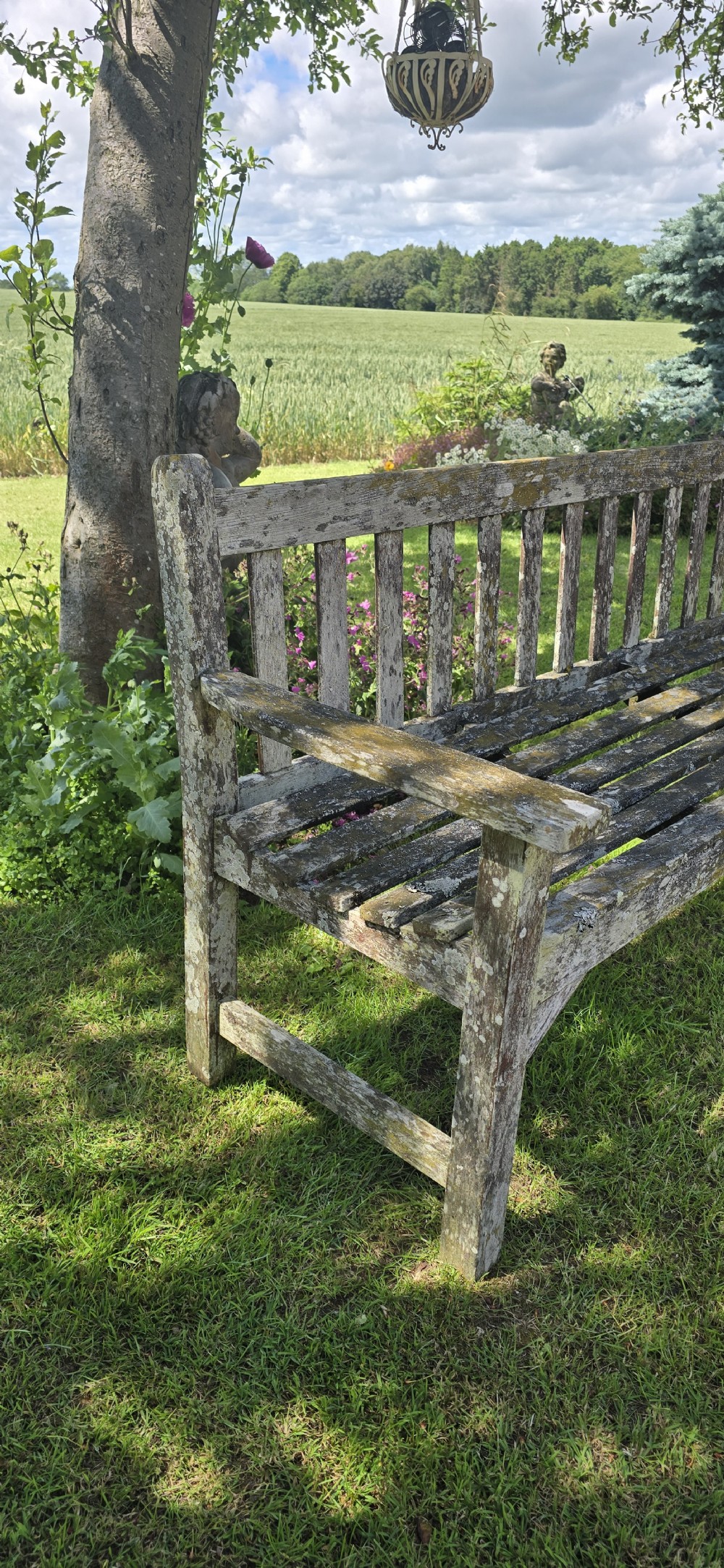 A rectangular slatted teak garden bench featuring a weathered grey oxidised finish, flat armrests, and square legs. View X