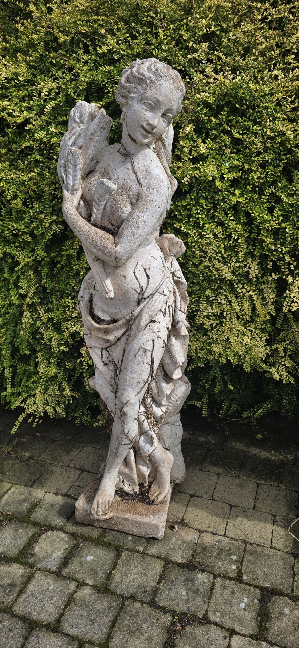 A set of four weathered grey stone full-length classical female statues representing the Four Seasons on rectangular bases. View IV