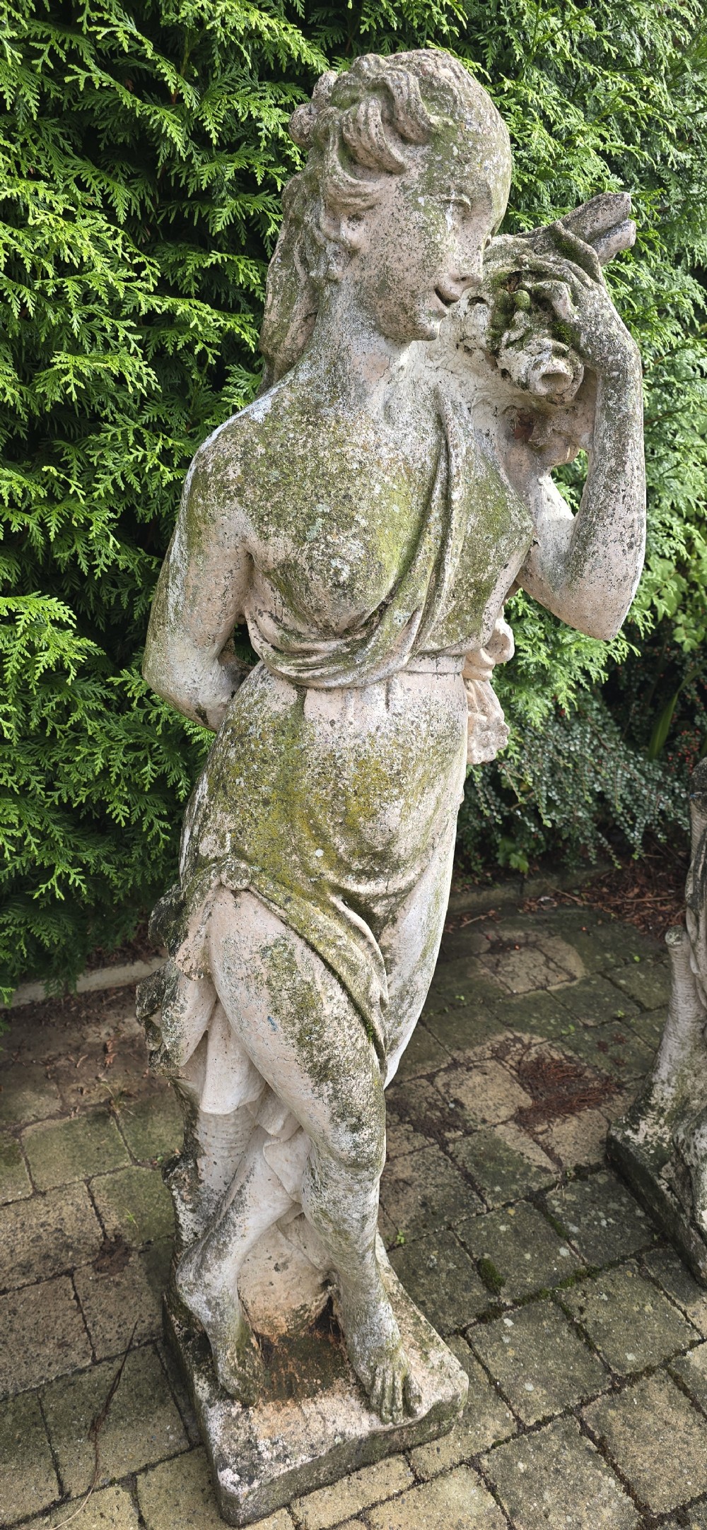 A set of four weathered grey stone full-length classical female statues representing the Four Seasons on rectangular bases. View VIII