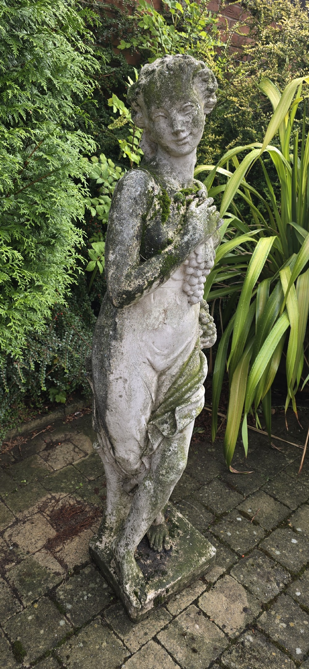 A set of four weathered grey stone full-length classical female statues representing the Four Seasons on rectangular bases. View X