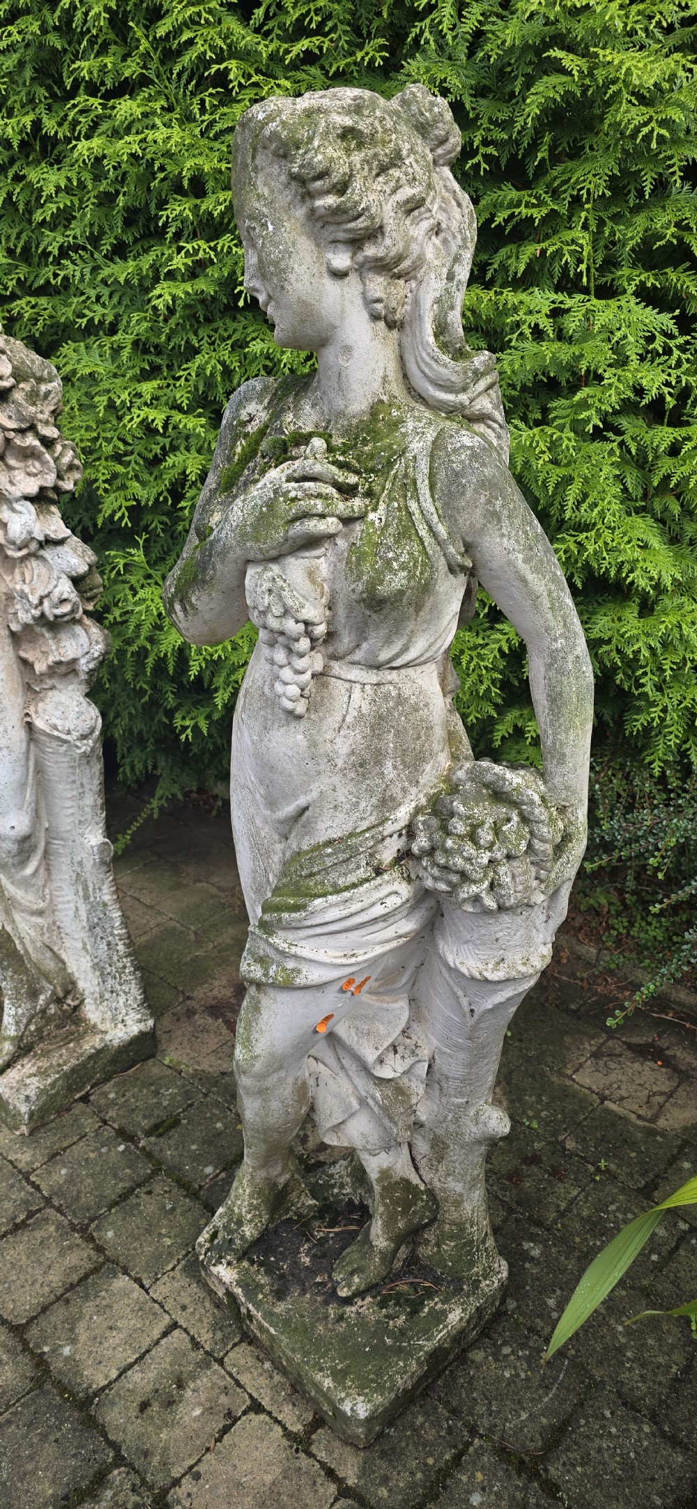 A set of four weathered grey stone full-length classical female statues representing the Four Seasons on rectangular bases. View XI