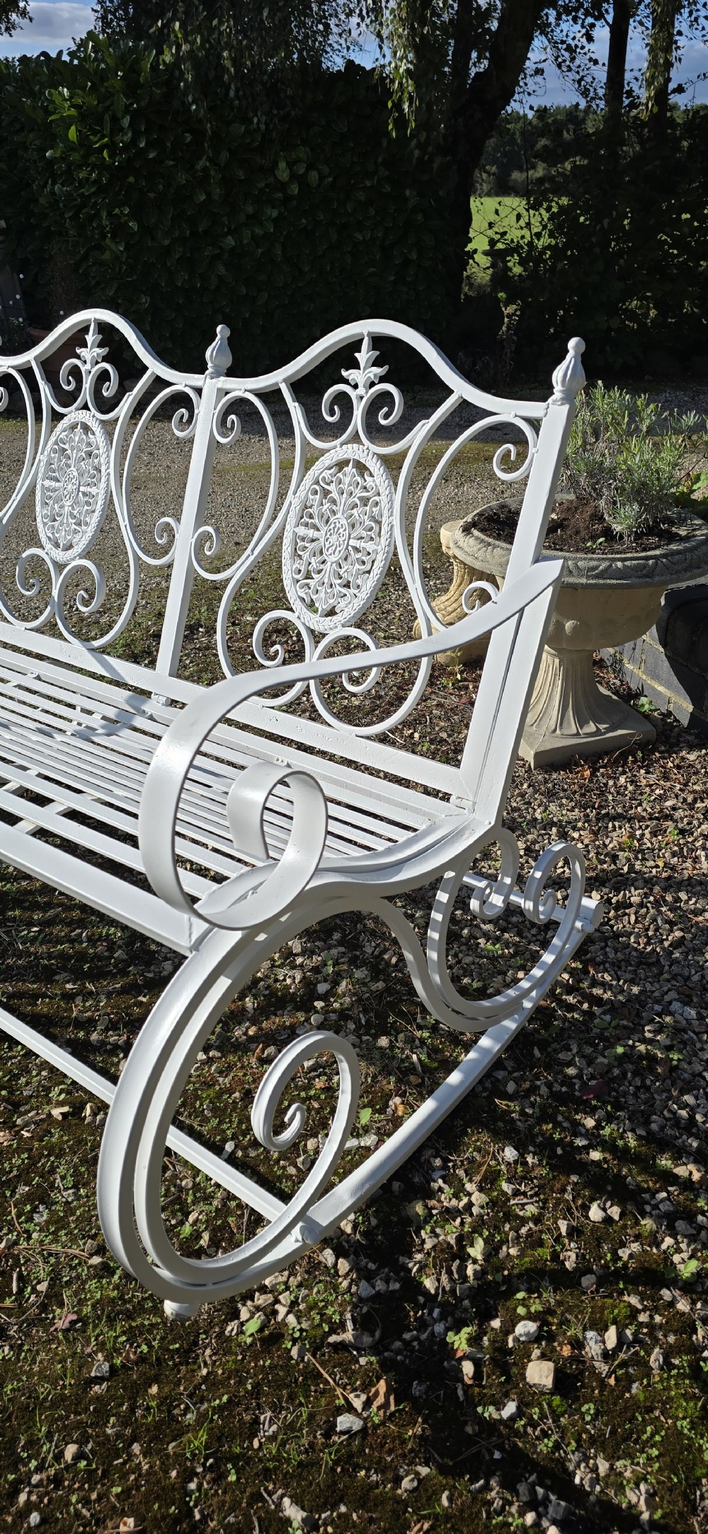 A pair of restored white-painted wrought iron garden rocking benches featuring ornate decorative scrollwork backrests and slatted seats. View IX