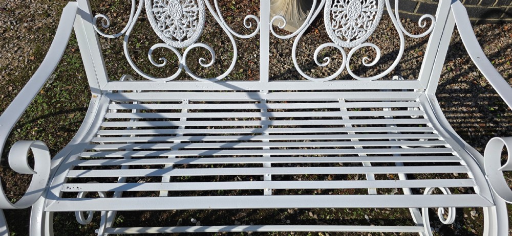 A pair of restored white-painted wrought iron garden rocking benches featuring ornate decorative scrollwork backrests and slatted seats. View XIV