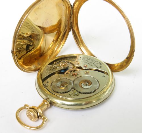 fig 1. An Edwardian open-face pocket watch featuring a gold-toned casing, dark Arabic numerals, an engine-turned dial centre, and a lower sub-seconds dial.
