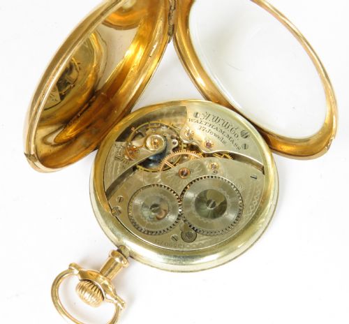 fig 2. An Edwardian open-face pocket watch featuring a gold-toned casing, dark Arabic numerals, an engine-turned dial centre, and a lower sub-seconds dial.