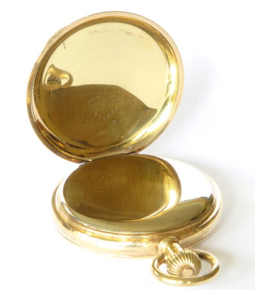 fig 2. An open antique gold full hunter pocket watch with a white enamel dial, black Roman numerals, and a subsidiary seconds sub-dial.