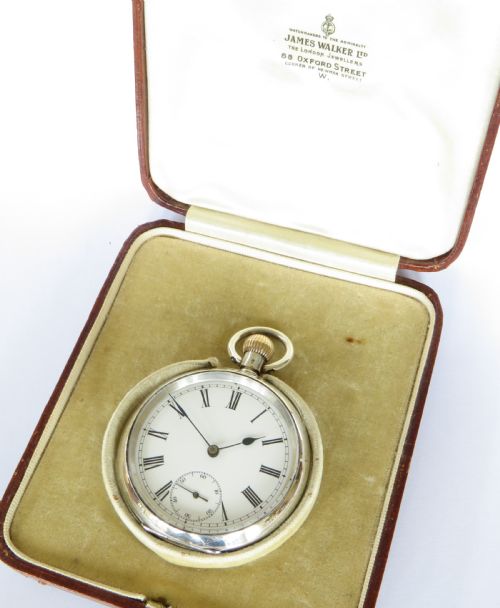 fig 1. An antique silver open-face pocket watch featuring a white enamel dial with black Roman numerals and a sub-seconds dial.
