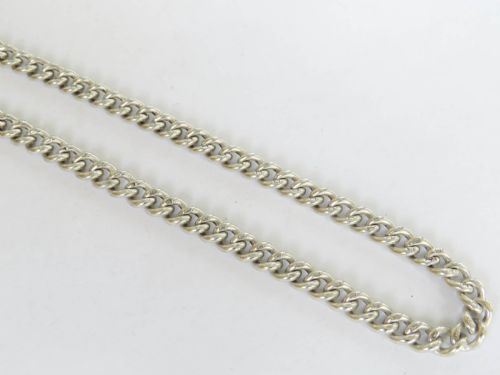 fig 1. An Edwardian sterling silver curb link watch chain featuring a T-bar, swivel clasp, and an enamel medallion fob accompanied by two silver sporting medals.