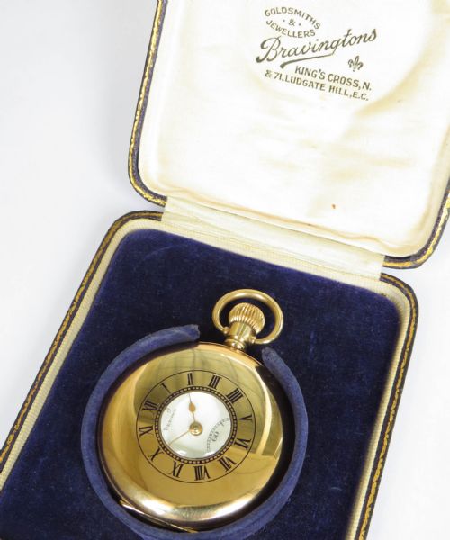 fig 2. A gold-plated half hunter pocket watch displayed open, featuring a white enamel dial with black Roman numerals and a subsidiary seconds dial.