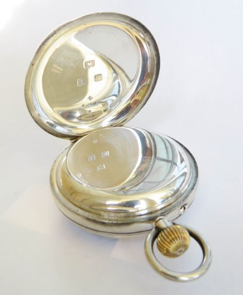 fig 2. An open-face antique silver pocket watch featuring a white enamel dial with black Roman numerals and a subsidiary seconds sub-dial.