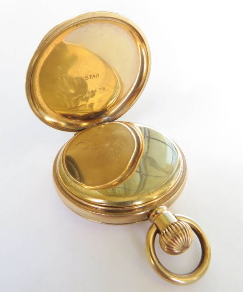 fig 1. An open gold-toned full hunter pocket watch displaying a white enamel dial with black Roman numerals and a subsidiary seconds dial.