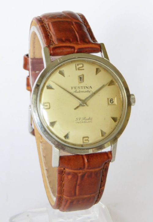 fig 1. A gents 1950s Festina automatic wristwatch featuring a champagne dial, silver-tone case, and brown leather strap.