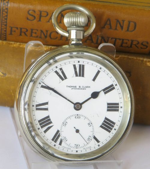 fig 1. An open-face 1920s silver pocket watch featuring a white enamel dial with black Roman numerals and a subsidiary seconds sub-dial.
