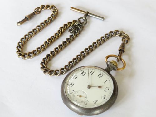 fig 1. An antique open-face pocket watch with a white enamel dial and black Arabic numerals, attached to a brass curb-link Albert chain with a T-bar.