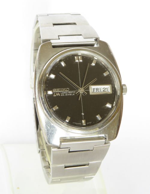 fig 1. A gents Seiko Lord Matic stainless steel automatic wristwatch featuring a black dial face with day-date display and integrated steel link bracelet.