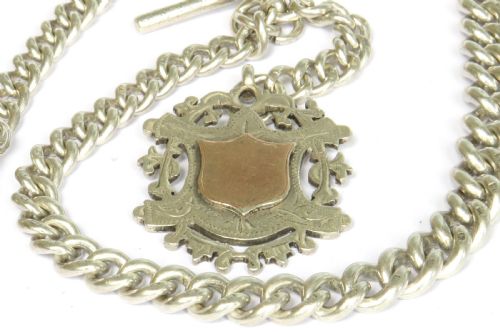 fig 1. An Edwardian sterling silver Albert pocket watch chain featuring curb links, a T-bar fastener, a swivel clasp, and a decorative shield-shaped fob with a rose gold cartouche.