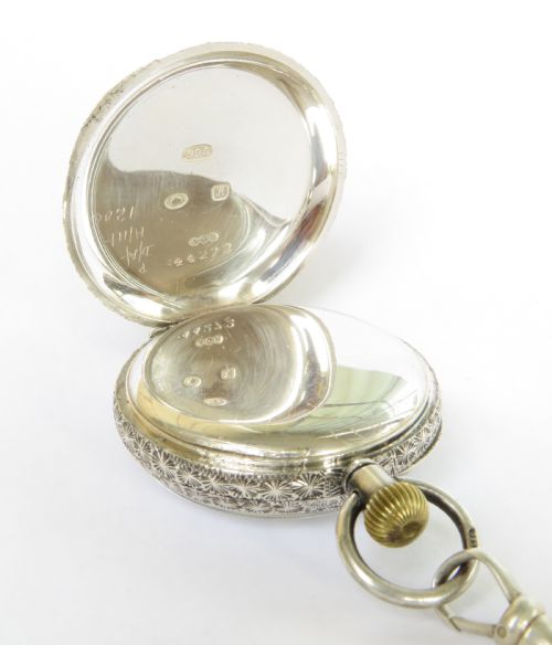 fig 2. An antique open-face silver pocket watch with a white enamel dial and Roman numerals, attached to a silver rope-twist Albert chain with a T-bar and engraved pendant.