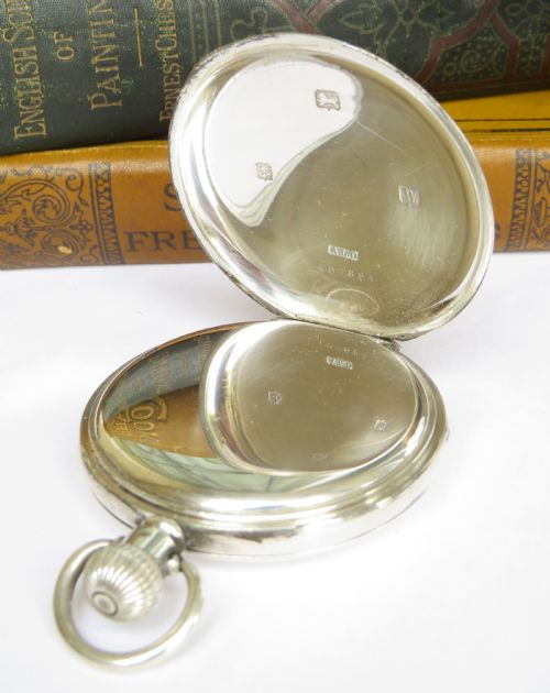 fig 1. An antique 1920s Elgin silver full hunter pocket watch shown open, featuring a white enamel dial with black Roman numerals and a small seconds sub-dial.