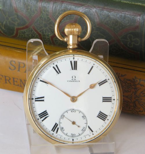 fig 1. An open-face 1930s Omega gold pocket watch featuring a white dial with black Roman numerals, a subsidiary seconds dial, and a top winding crown ring.
