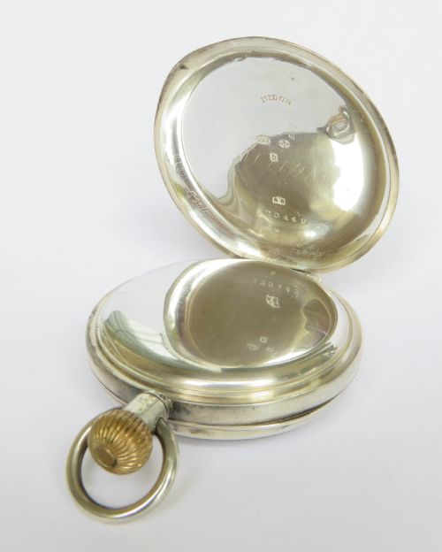 fig 2. An open-face antique silver pocket watch featuring a white enamel dial with black Roman numerals and a subsidiary seconds sub-dial.