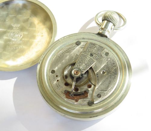 fig 2. An antique silver-tone open-face pocket watch featuring a white enamel dial with black Roman numerals and a subsidiary seconds dial.